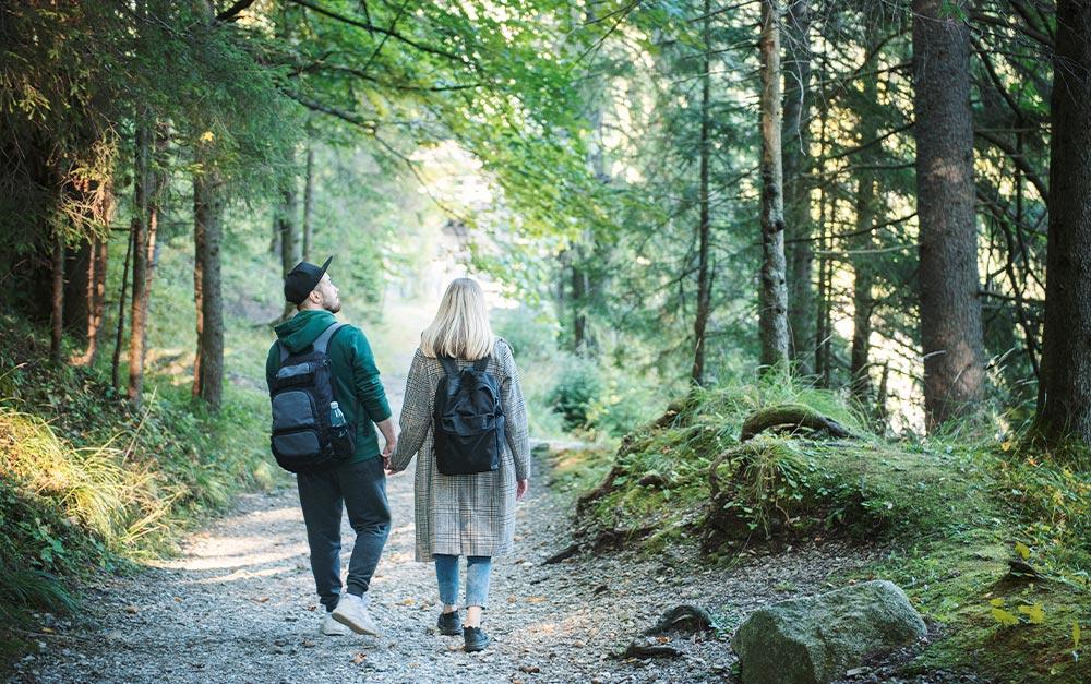 A imagem mostra um casal explorando parques nacionais.
