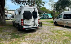 Imagem de um motorhome em um camping estacionado, pronto para ser usado em uma viagem.