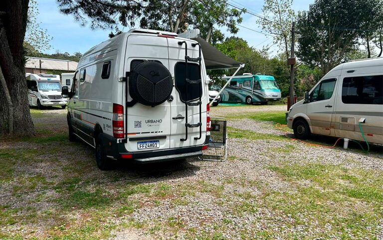 Imagem de um motorhome em um camping estacionado, pronto para ser usado em uma viagem.