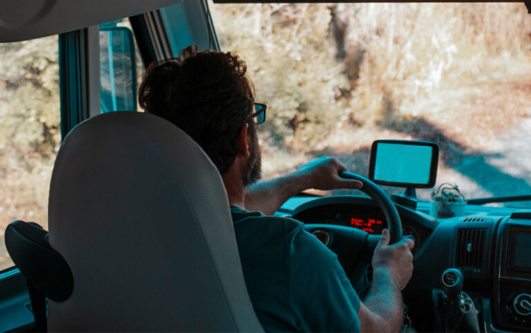 Imagem de um homem dirigindo seu motorhome rumo a suas viagens.